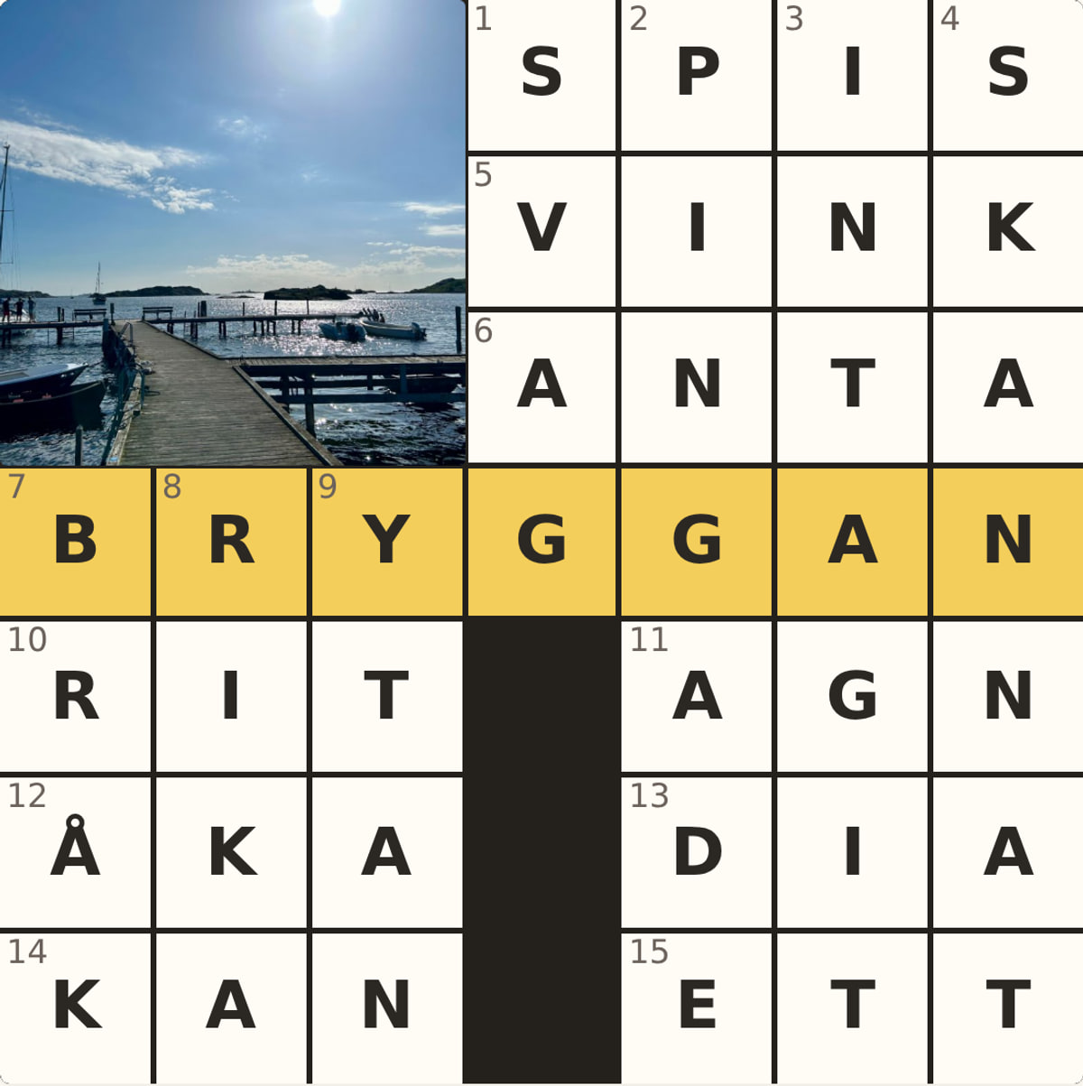 Ett krysskort: ett löst korsord med ett foto från en brygga infällt i rutnätet, och temaordet BRYGGAN i den gula raden.